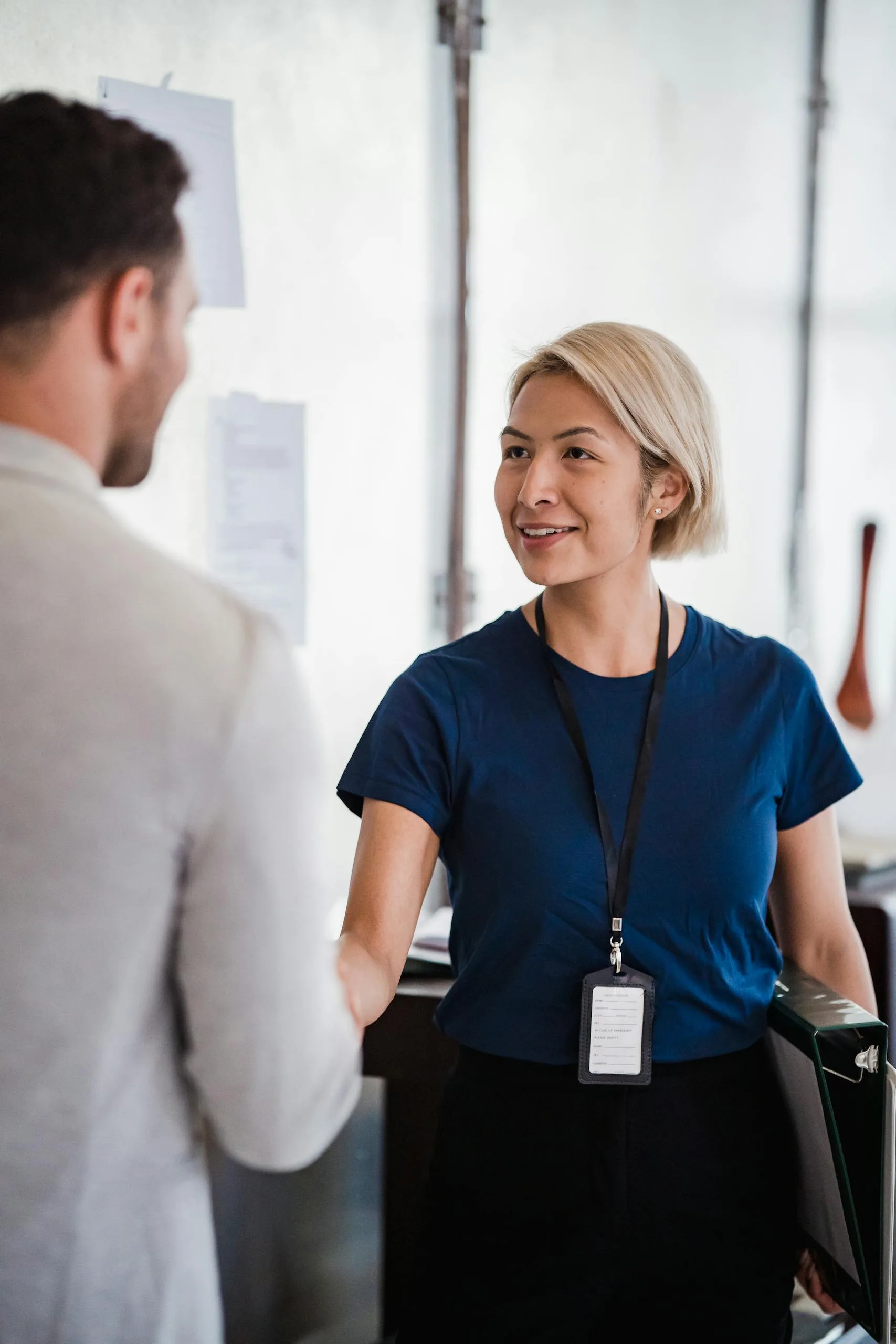 Friendly handshake between business professionals in an office environment, emphasizing teamwork.