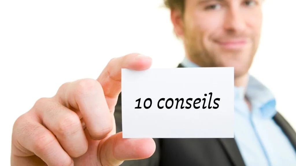 Homme flouté tenant une carte avec l’inscription « 10 conseils » vers l’objectif.